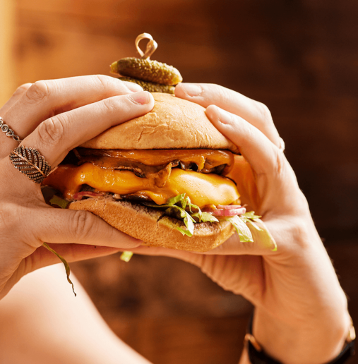 Illustration of a shaded seat under a large umbrella on a tranquil beach, with calm waves in the background and the sun setting on the horizon.