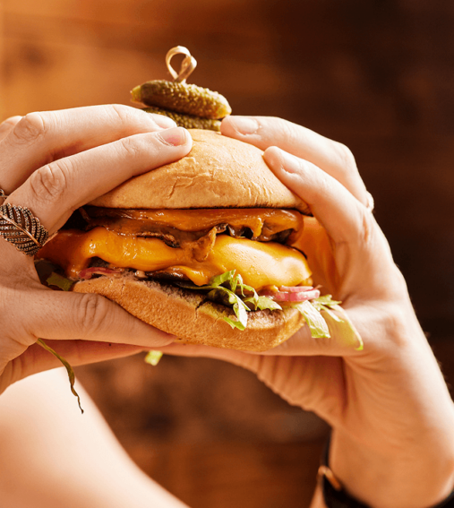 Illustration of a shaded seat under a large umbrella on a tranquil beach, with calm waves in the background and the sun setting on the horizon.