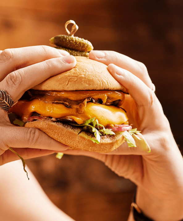 Illustration of a shaded seat under a large umbrella on a tranquil beach, with calm waves in the background and the sun setting on the horizon.