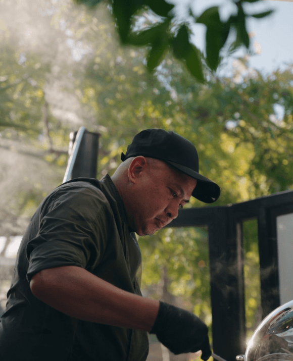 A modern hotel room featuring two neatly made beds, a floor-length window with city view, bedside tables with lamps, and a wall-mounted TV. Bright, inviting atmosphere.