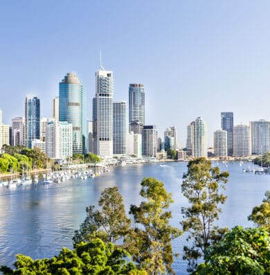 Brisbane Cityscape with a river and a lot of tall buildings under the blue sky with blue water river surrounded by trees in a sunny day in Queensland, Australia.