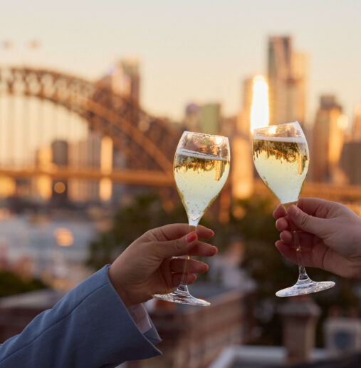 Two champagne glasses cheers over sydney harbour