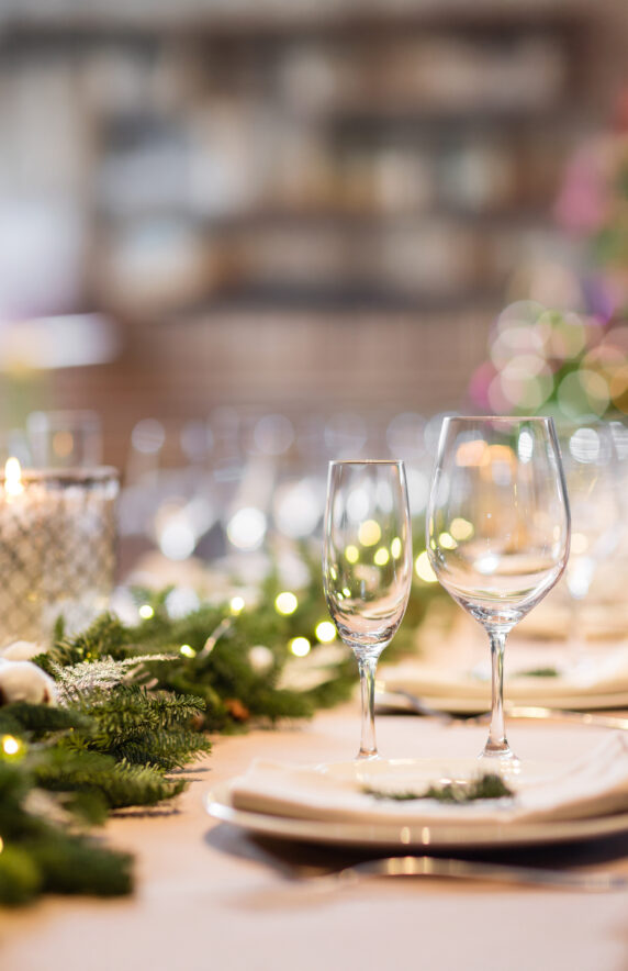 Christmas dinner feast. A decorated dining table with champagne glasses and christmas tree in background