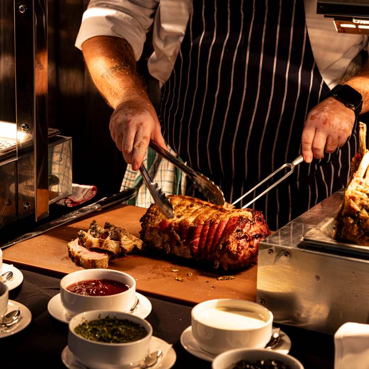 Aerial view of a bustling cityscape with high-rise buildings, lush greenery, and a central river. Overcast sky with scattered clouds adds depth to the urban scene.