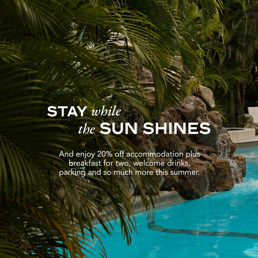 A cityscape of Brisbane, featuring the iconic Story Bridge, skyscrapers, and a clear blue sky reflecting on the Brisbane River.