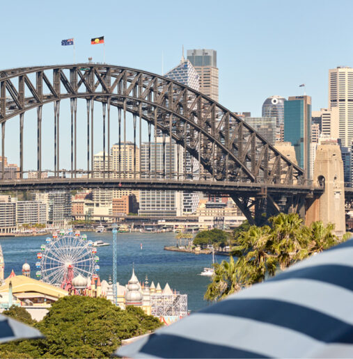 Business meeting with seven diverse professionals seated at a table, engaged in discussion and looking at documents in a modern office setting.