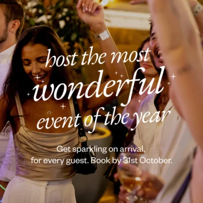 Guests enjoying a lively hotel event with drinks, warm lighting, and festive atmosphere, perfect for hosting celebrations.