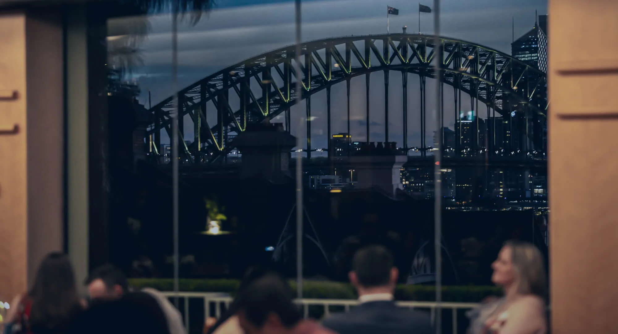 The Sydney Harbour Bridge seen through the windows of LB's Restaurant at dusk
